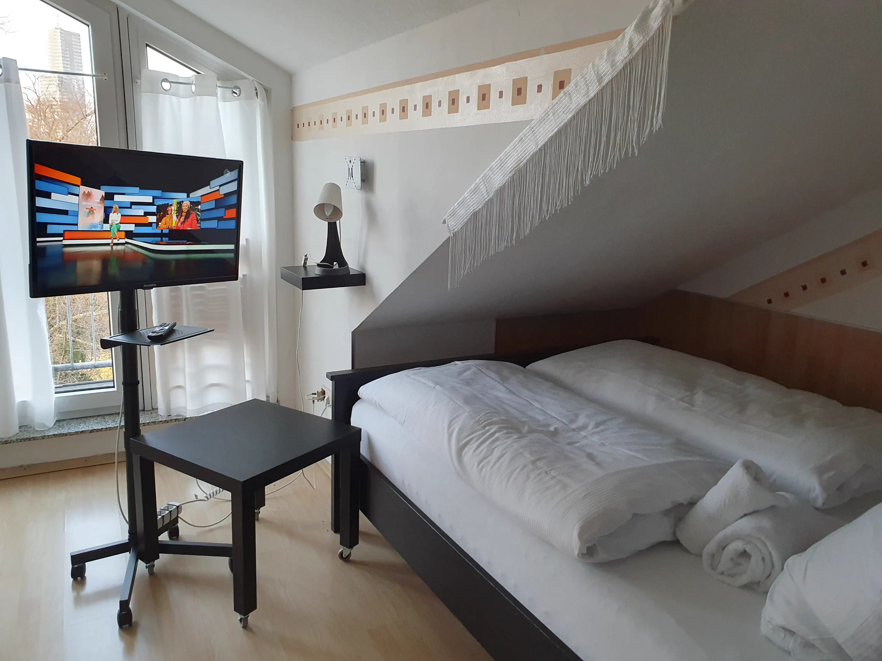Queen-Bett und Smart-TV im Studio mit Parkblick